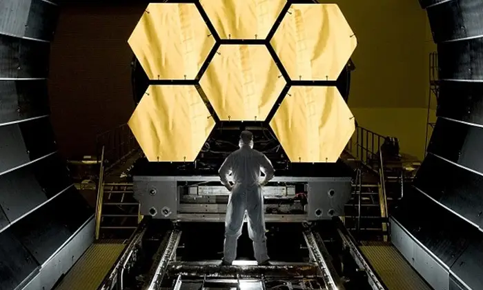 Man inspecting a satellite manufacturing