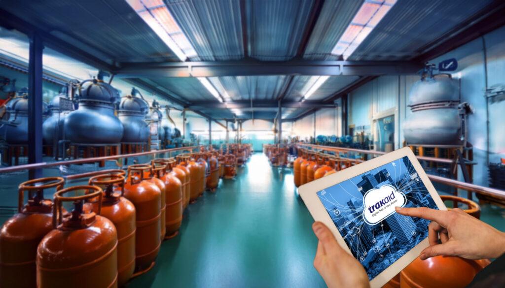 A person holding a tablet in front of a row of propane tanks