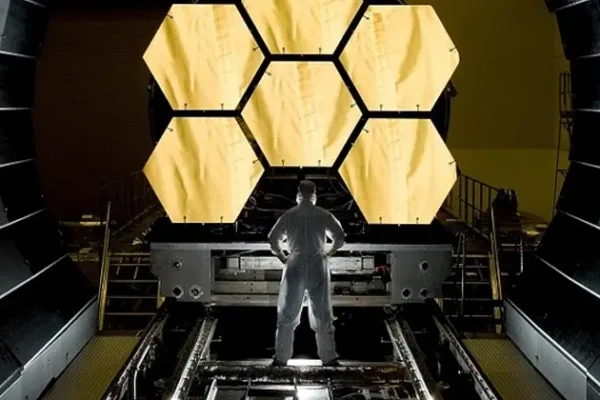 Man inspecting a satellite manufacturing